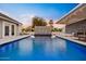 A luxurious backyard pool features a captivating water feature, abundant seating, and an adjacent lounge area at 16409 N 65Th Pl, Scottsdale, AZ 85254