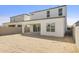 A large backyard featuring a covered patio with an outer brick fence and open space for future landscaping at 17837 W Mission Ln, Waddell, AZ 85355