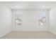 Spacious bedroom with two large windows, neutral carpet, and white walls at 17837 W Mission Ln, Waddell, AZ 85355