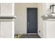 Stylish home features a covered entryway with a gray front door and brick walkway at 17837 W Mission Ln, Waddell, AZ 85355