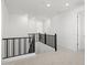 Upstairs hallway featuring black railing, recessed lighting, neutral carpet, and white doors at 17837 W Mission Ln, Waddell, AZ 85355