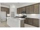 Bright kitchen featuring a large island with white countertops and brown cabinets and stainless steel appliances at 17837 W Mission Ln, Waddell, AZ 85355