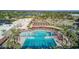 Aerial view of the community pool, splashpad and lounging area surrounded by palm trees and green spaces at 18522 N Mica Dr, Sun City West, AZ 85375