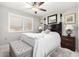 Cozy bedroom featuring a ceiling fan, a bench, and white bedding, creating a calm atmosphere at 18522 N Mica Dr, Sun City West, AZ 85375