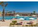 Inviting community pool with lap lanes and recreational areas, enhanced by sunny skies and tall palms at 18522 N Mica Dr, Sun City West, AZ 85375