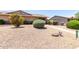 A low maintenance front yard featuring gravel, bushes, and a well-defined walkway, with a clean house exterior in the background at 18522 N Mica Dr, Sun City West, AZ 85375