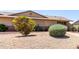 A charming tan house with a well-maintained front yard that features desert landscaping, adding to the home's curb appeal at 18522 N Mica Dr, Sun City West, AZ 85375