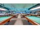 Expansive game room featuring multiple well-maintained billiards tables under ample lighting at 18522 N Mica Dr, Sun City West, AZ 85375