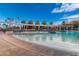 A beautiful community swimming pool is surrounded by lounge chairs and sun umbrellas under a blue sky with wispy clouds at 18522 N Mica Dr, Sun City West, AZ 85375