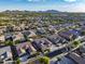 Picturesque aerial view of a residential neighborhood with lush landscaping, pools, and mountain views on a clear day at 21283 E Camacho Rd, Queen Creek, AZ 85142