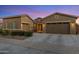 Charming single-Gathering home featuring desert landscaping, multi-car garage, and a welcoming facade under a beautiful twilight sky at 21283 E Camacho Rd, Queen Creek, AZ 85142
