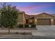 Attractive home with desert landscaping, multi-car garage, and a welcoming entrance complemented by the surrounding greenery at 21283 E Camacho Rd, Queen Creek, AZ 85142