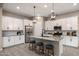 Contemporary kitchen featuring white cabinets, stainless steel appliances, and a center island with barstool seating at 21283 E Camacho Rd, Queen Creek, AZ 85142