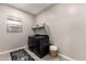 Functional laundry room with black appliances, storage shelves and a stylish rug at 21283 E Camacho Rd, Queen Creek, AZ 85142
