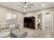 Stylish living room featuring modern ceiling fan, ottoman and entertainment center at 21283 E Camacho Rd, Queen Creek, AZ 85142