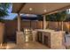 A complete outdoor kitchen with a built-in grill, bar area, and ample counter space for entertaining at 21283 E Camacho Rd, Queen Creek, AZ 85142