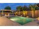 Sparkling pool with fountains, a covered bar area, and beautiful landscaping create a resort-like backyard oasis at 21283 E Camacho Rd, Queen Creek, AZ 85142