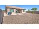 Home exterior featuring a patio, gravel landscaping, and trash bins at 21551 E Waverly Ct, Queen Creek, AZ 85142