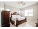 Well-lit bedroom featuring a decorative headboard, ceiling fan, and ample natural light at 21551 E Waverly Ct, Queen Creek, AZ 85142