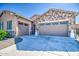 Home showcasing an extended driveway leading to a three-car garage, with stone detailing on the exterior at 21551 E Waverly Ct, Queen Creek, AZ 85142