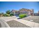 Home featuring a three-car garage, stone veneer accents, well-manicured landscaping, and a spacious driveway at 21551 E Waverly Ct, Queen Creek, AZ 85142
