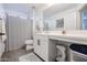 Well-lit bathroom featuring a sink with modern fixtures and a shower, with a neutral color palette at 2158 N 212Th Ave, Buckeye, AZ 85396