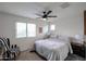 Comfortable bedroom with natural light, a ceiling fan, and a cozy chair, creating a relaxing space at 2158 N 212Th Ave, Buckeye, AZ 85396