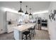 The kitchen features stainless steel appliances, a spacious island with seating, and sleek countertops at 2158 N 212Th Ave, Buckeye, AZ 85396
