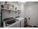 Bright laundry room with shelving, providing ample storage and convenience with modern washer and dryer units at 2158 N 212Th Ave, Buckeye, AZ 85396