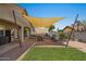 Inviting backyard features artificial turf, a covered patio, a full outdoor kitchen, and a cozy fire pit at 21720 E Domingo Rd, Queen Creek, AZ 85142