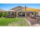 Beautiful backyard featuring a covered patio, hot tub, lush grass, and an outdoor kitchen perfect for entertaining at 21720 E Domingo Rd, Queen Creek, AZ 85142