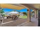 Beautiful covered patio with an outdoor kitchen and dining area overlooks the well-maintained backyard at 21720 E Domingo Rd, Queen Creek, AZ 85142