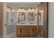 Bathroom featuring double vanity, a glass shower, decorative mirrors, and a barn-style door at 21720 E Domingo Rd, Queen Creek, AZ 85142