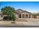 Inviting single-story home with a well-manicured front yard, desert landscaping, and an arched covered porch at 21720 E Domingo Rd, Queen Creek, AZ 85142