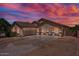 Charming single-story home with desert landscaping, arched entryway, and a two-car garage under a vibrant sunset at 21720 E Domingo Rd, Queen Creek, AZ 85142