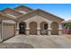 Welcoming single-story home with an arched covered porch and desert landscaping with a spacious driveway at 21720 E Domingo Rd, Queen Creek, AZ 85142