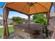 Relax in the backyard hot tub, sheltered by a gazebo, surrounded by lush greenery and serene landscaping at 21720 E Domingo Rd, Queen Creek, AZ 85142