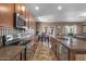 Well-equipped kitchen with stainless steel appliances, a dining area, and an adjacent living space at 21720 E Domingo Rd, Queen Creek, AZ 85142