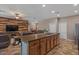 Open-concept kitchen with a large island, breakfast bar, and modern wood panel wall in the living area at 21720 E Domingo Rd, Queen Creek, AZ 85142