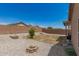 Spacious backyard showcasing low maintenance landscaping with gravel and defined fire pit areas at 22544 W Mohave St, Buckeye, AZ 85326