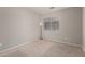 Neutral bedroom with carpet, window and minimalist floor lamp and wall plug outlets at 22544 W Mohave St, Buckeye, AZ 85326