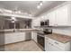 Bright kitchen features stainless appliances, sleek white cabinets, and tile flooring at 22544 W Mohave St, Buckeye, AZ 85326