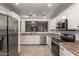 Bright kitchen features stainless appliances, sleek white cabinets, and tile flooring at 22544 W Mohave St, Buckeye, AZ 85326