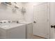 Functional laundry room featuring a full-size washer and dryer with wire rack storage at 22544 W Mohave St, Buckeye, AZ 85326