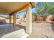 Open backyard featuring patio, gravel landscaping, brick retaining wall, and various desert trees and bushes at 2306 W Spur Dr, Phoenix, AZ 85085
