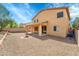 Two story house featuring a covered patio, gravel landscape, fire pit area, and desert trees at 2306 W Spur Dr, Phoenix, AZ 85085