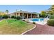 A lush backyard features a pool, covered patio, and manicured lawn at 23213 N Del Monte Dr, Sun City West, AZ 85375