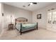 Comfortable bedroom boasts natural lighting, a wrought iron bed frame, and carpet flooring at 23213 N Del Monte Dr, Sun City West, AZ 85375