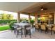 Outdoor covered patio features an outdoor kitchen, bar, dining area, and ceiling fan at 23213 N Del Monte Dr, Sun City West, AZ 85375