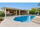 View of the backyard with swimming pool, covered patio, and outdoor kitchen at 23213 N Del Monte Dr, Sun City West, AZ 85375